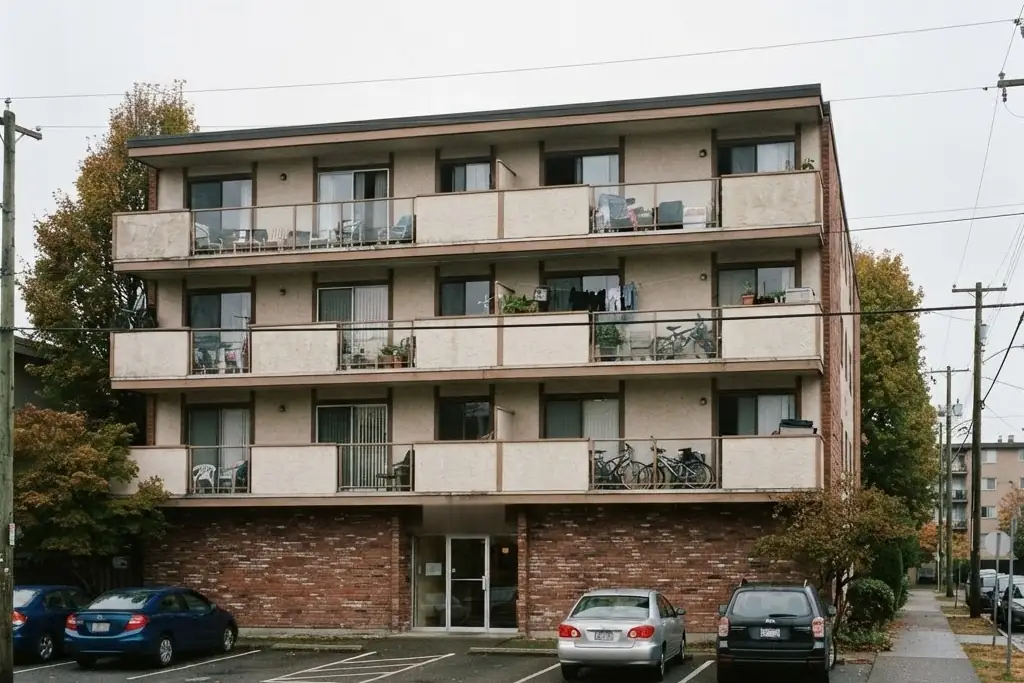 A four storey low rise rental apartment building with balconies on every floor and parking in front, for apartment property management in Brampton