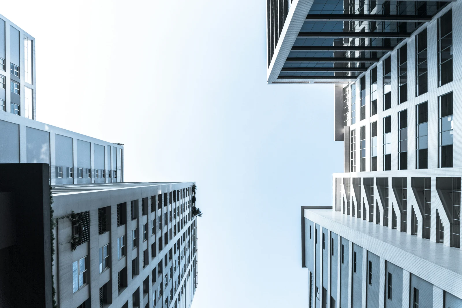 Looking up at modern apartment towers against a pale sky, for condo property management in Brampton