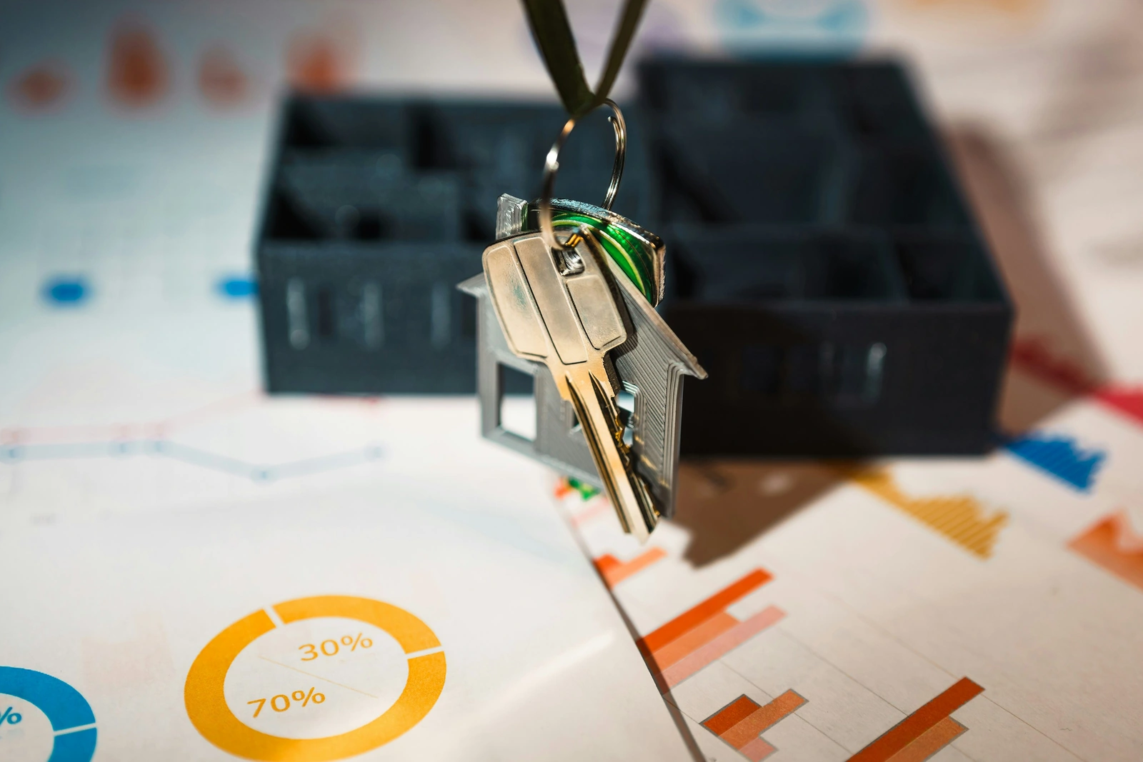 A house keyring and keys resting on printed charts, for property management services in Brampton