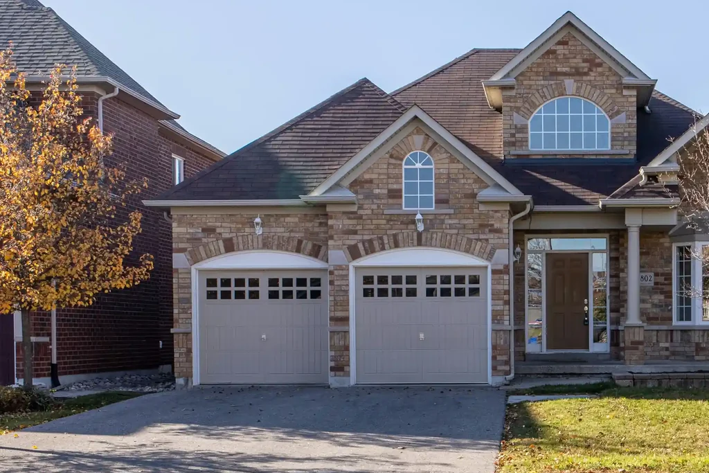 A brick family home with a double garage seen from the street